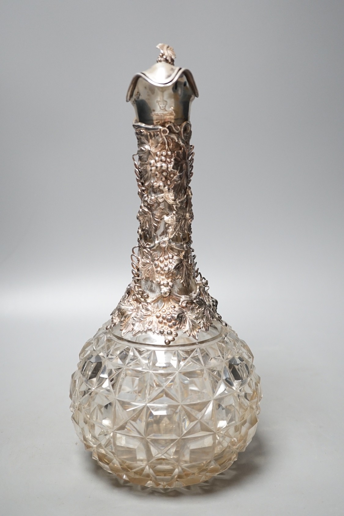 A Victorian silver mounted cut glass claret jug, with fruiting vine decoration, Cartwright & Woodward, Birmingham, 1860, 32cm.